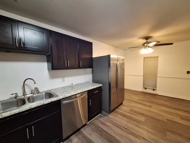 a kitchen with stainless steel appliances granite countertop a sink stove and refrigerator