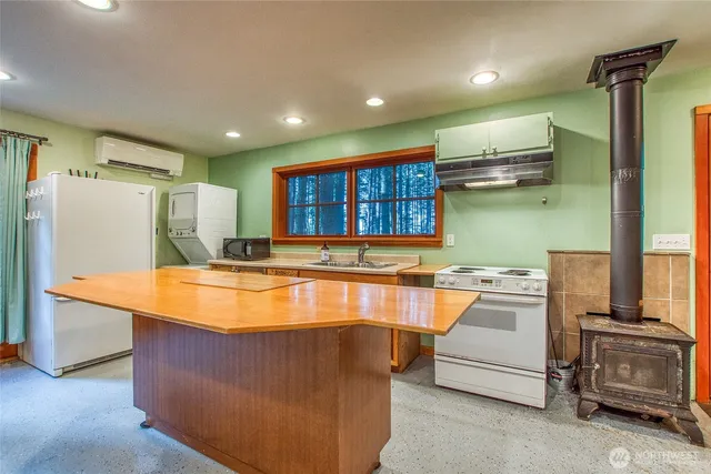 a open kitchen with stainless steel appliances granite countertop a stove top oven a sink and a refrigerator