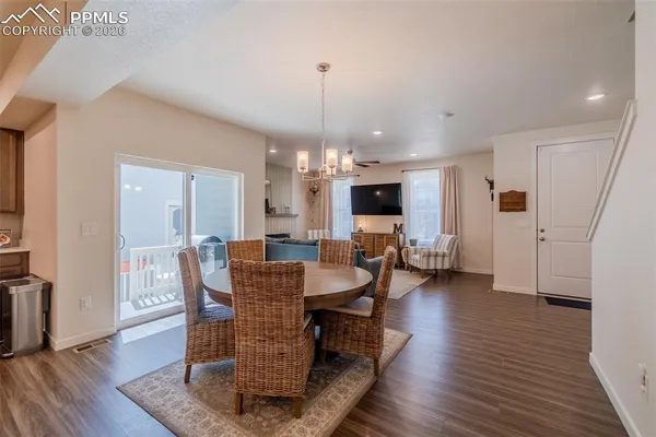 a dining room with furniture a chandelier and wooden floor