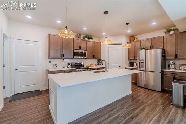 a kitchen with kitchen island a refrigerator sink and cabinets