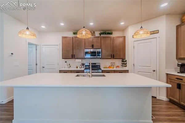 a large kitchen with kitchen island a sink stainless steel appliances and cabinets