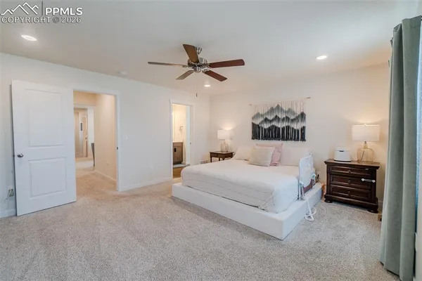 a spacious bedroom with a bed and dresser