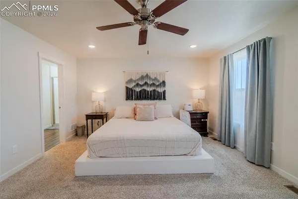 a spacious bedroom with a bed and a chandelier