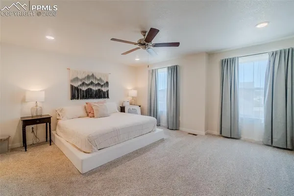 a spacious bedroom with a bed and a chandelier