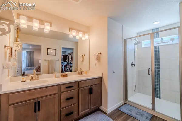 a bathroom with a double vanity sink mirror and shower