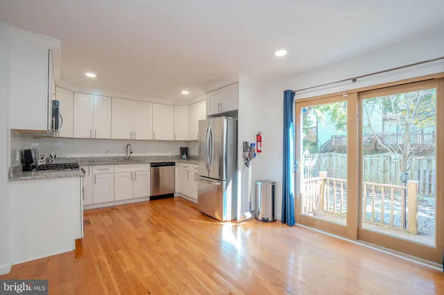 a kitchen with a refrigerator and white cabinets