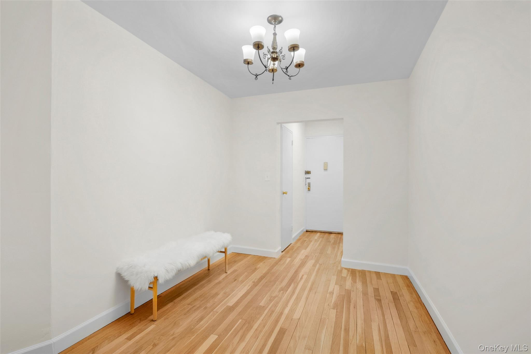 325 Palmer Terrace, Unit 2C Mamaroneck, NY 10543 - Photo 4 of 18 a view of a room with wooden floor and chandelier