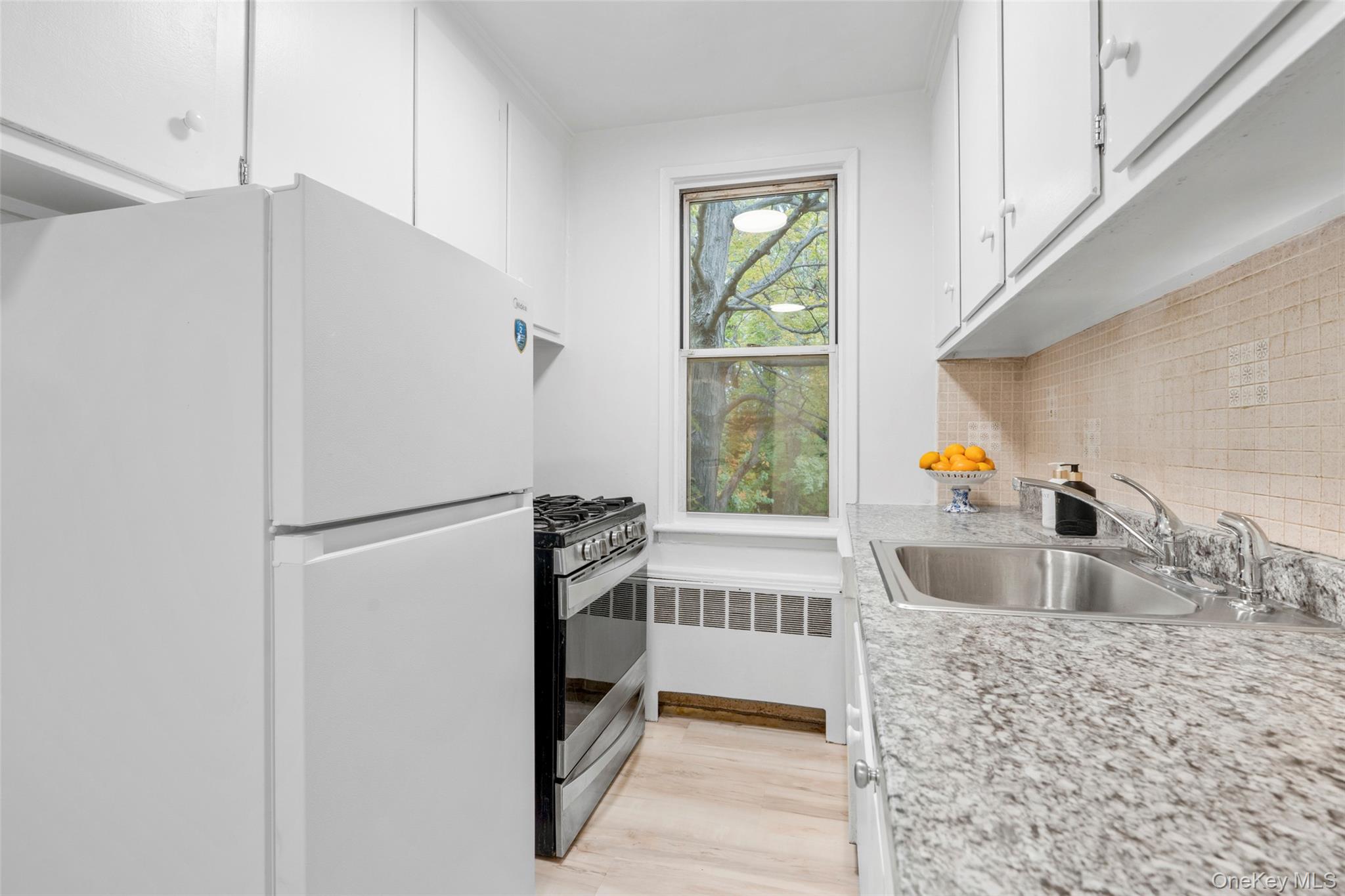 325 Palmer Terrace, Unit 2C Mamaroneck, NY 10543 - Photo 9 of 18 a kitchen with granite countertop a refrigerator and a sink