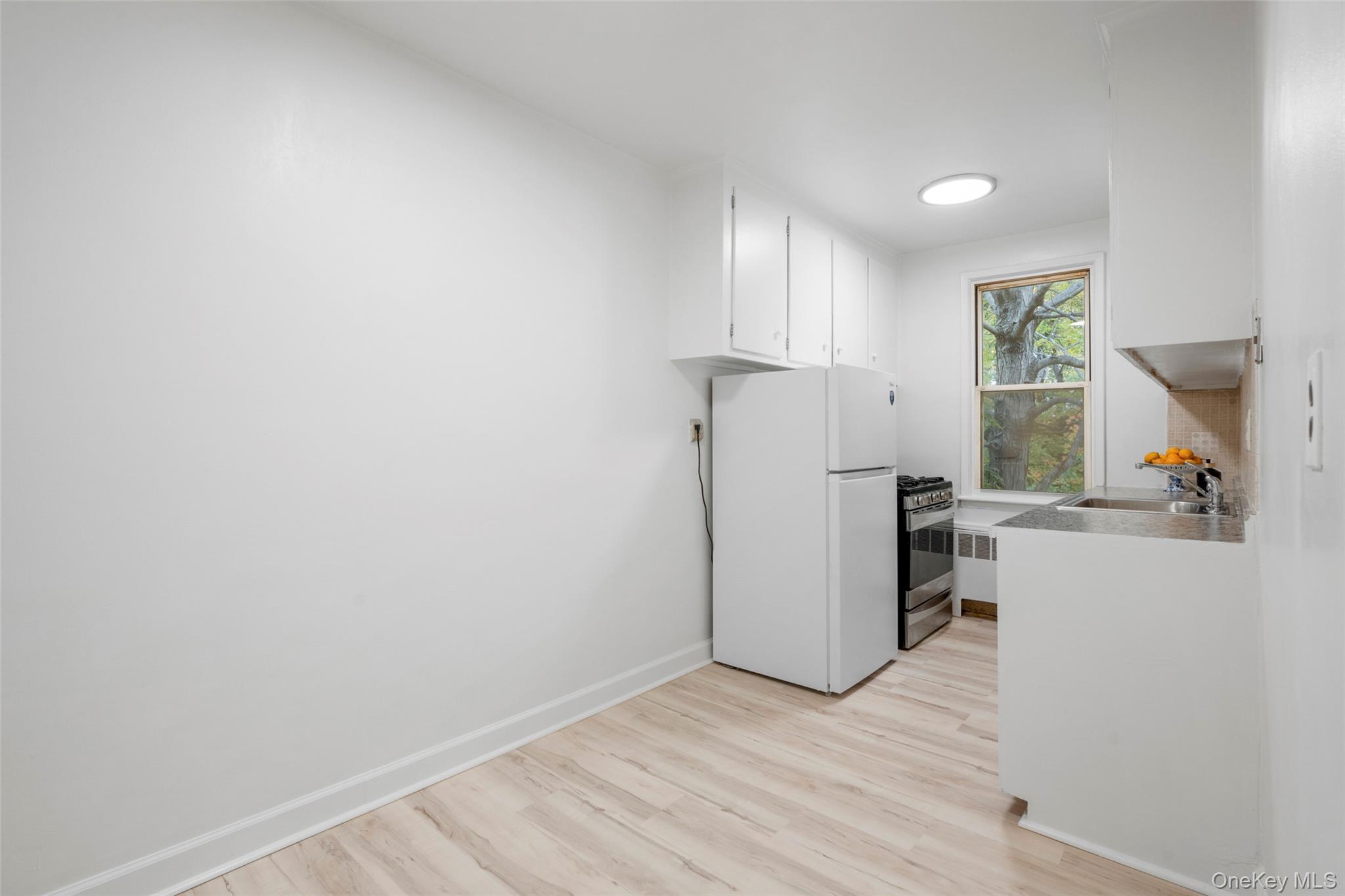 325 Palmer Terrace, Unit 2C Mamaroneck, NY 10543 - Photo 10 of 18 a view of a kitchen with a sink refrigerator and wooden floor