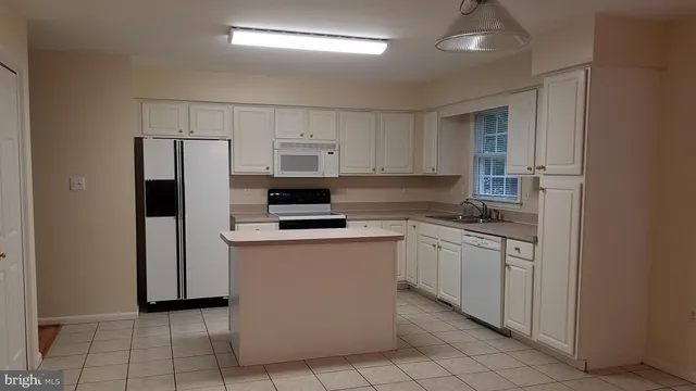 a kitchen with stainless steel appliances a refrigerator sink and microwave