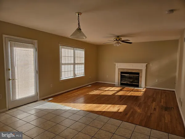 a view of an empty room with a fireplace and a window