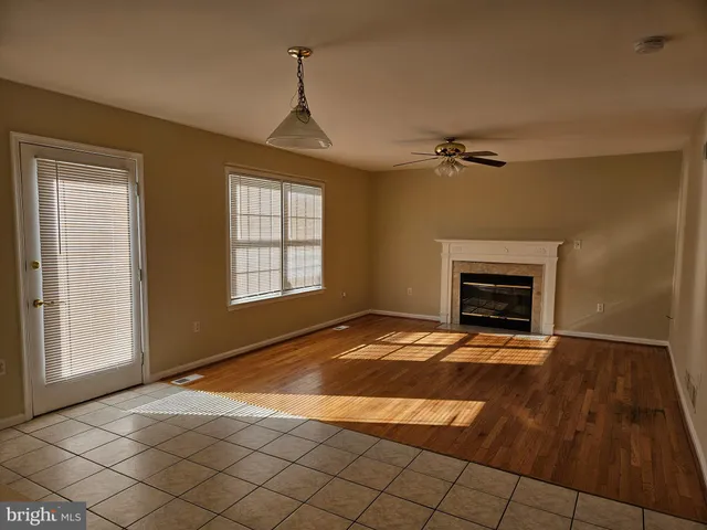 a view of an empty room with a fireplace and a window