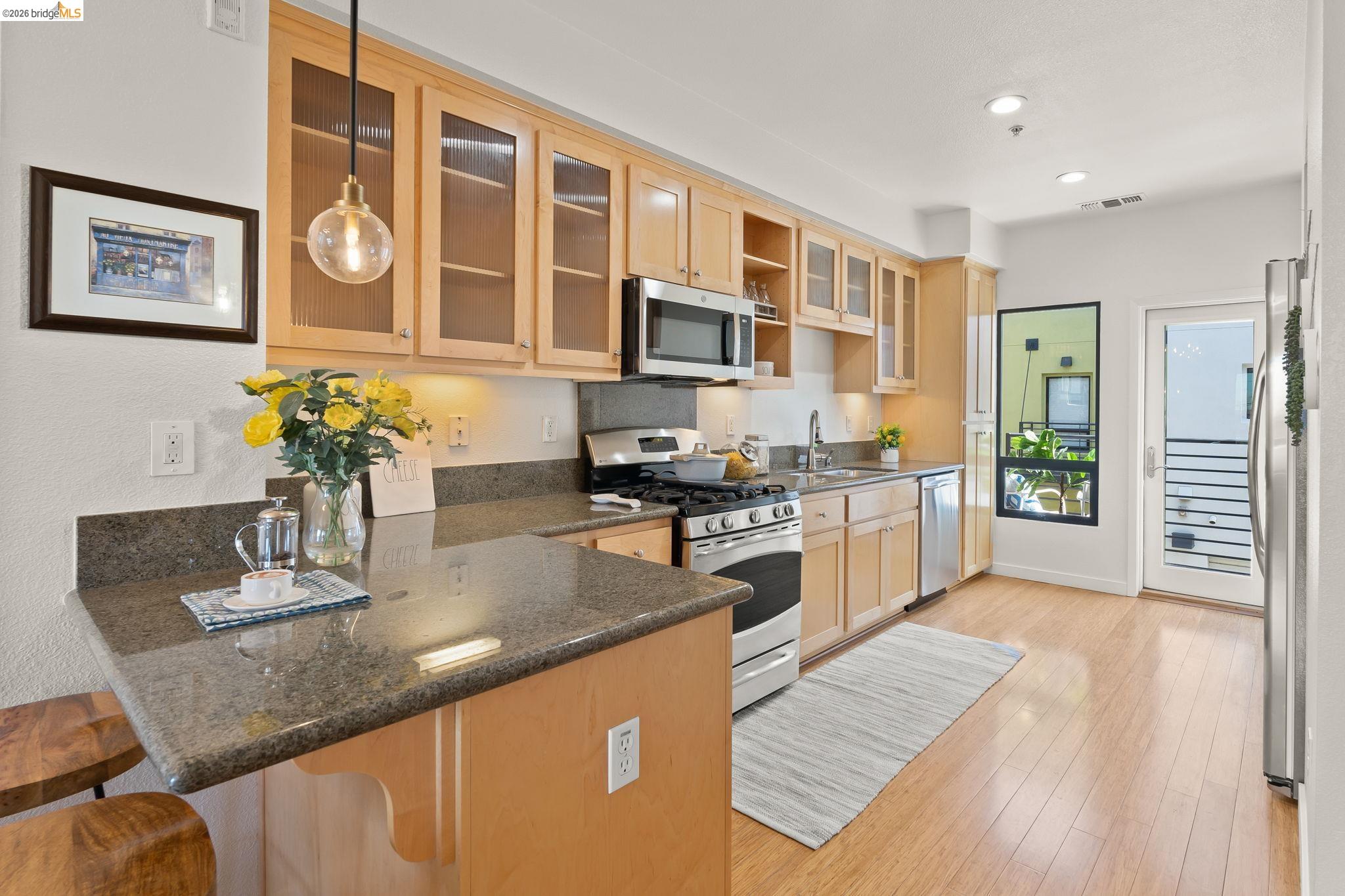 1780 12th Street Oakland, CA 94607 - Photo 6 of 31 a kitchen with stainless steel appliances granite countertop a stove and cabinets
