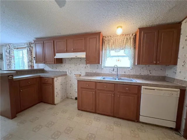 a kitchen with sink a window and cabinets