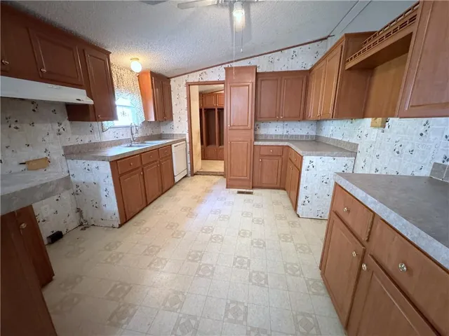 a kitchen with granite countertop a sink stove and cabinets