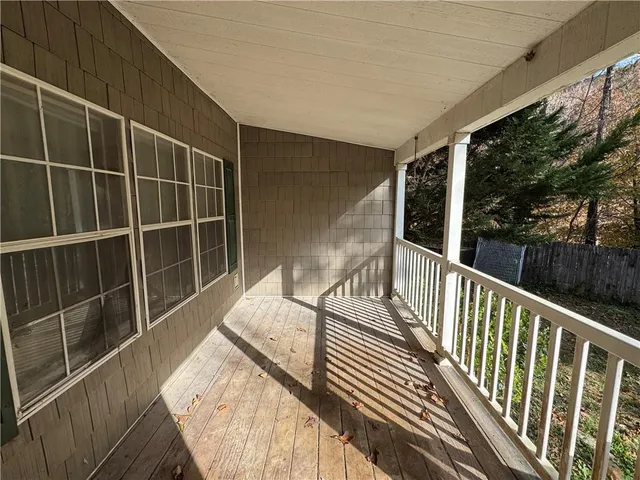 a view of balcony with wooden floor and fence