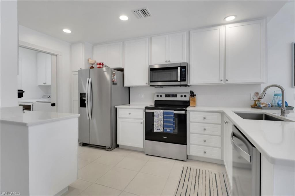3570 Zanzibar Way Naples, FL 34119 - Photo 12 of 43 a kitchen with stainless steel appliances a refrigerator stove and sink