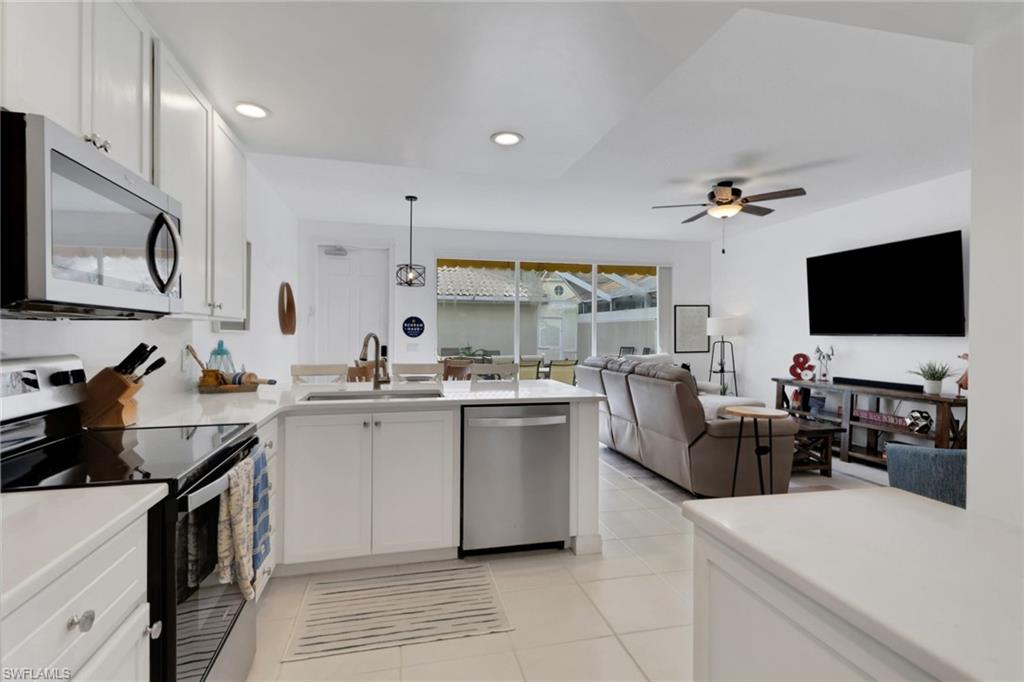 3570 Zanzibar Way Naples, FL 34119 - Photo 14 of 43 a kitchen with sink a stove and cabinets