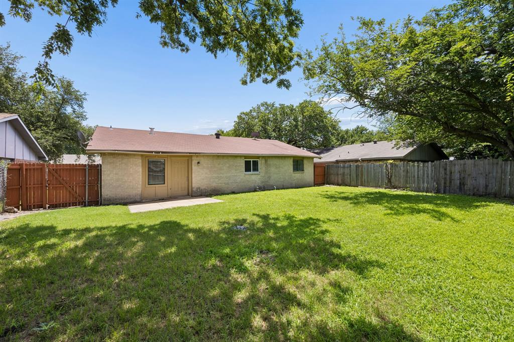 6221 Pine Street Rowlett, TX 75089 - Photo 12 of 12 Spacious backyard with a large grass lawn, mature perimeter trees, and wood fencing