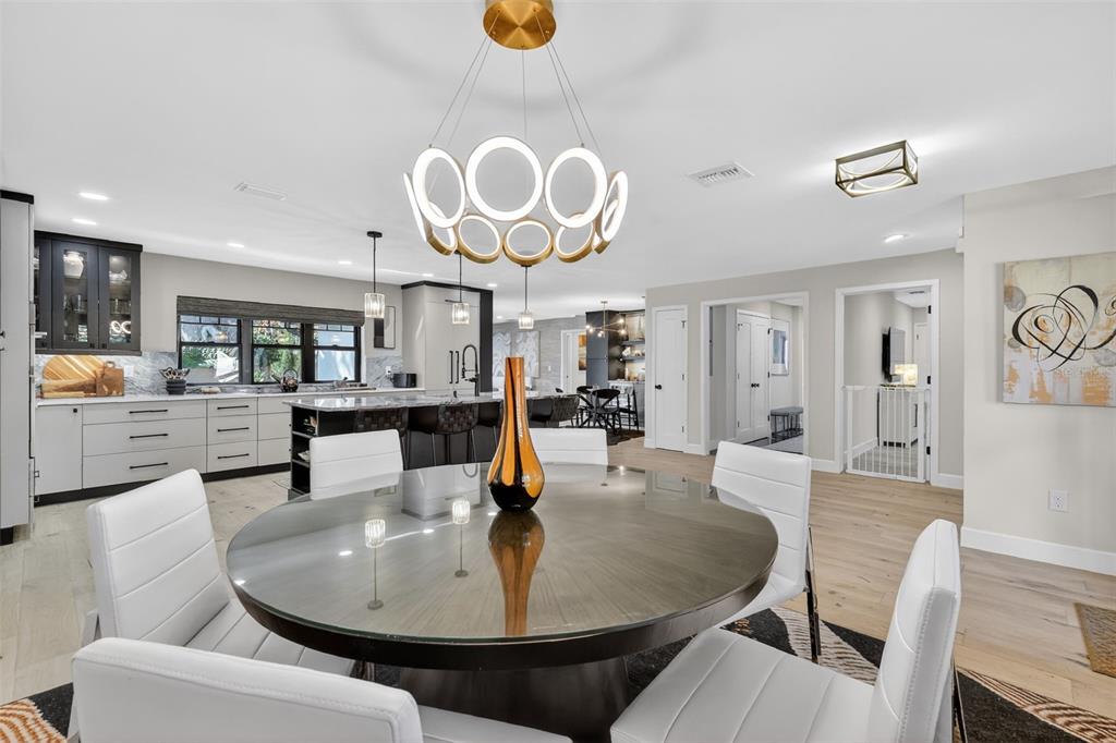 241 Bay Road Mount Dora, FL 32757 - Photo 13 of 57 a dining room with wooden floor a chandelier a wooden table and chairs