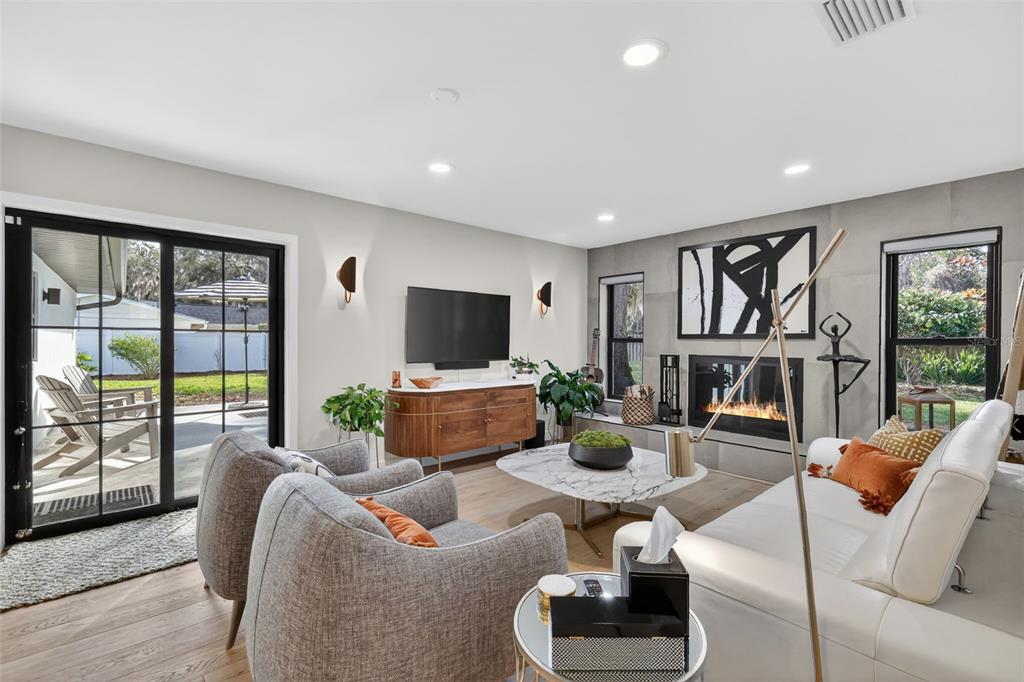 241 Bay Road Mount Dora, FL 32757 - Photo 21 of 57 a living room with furniture floor to ceiling window and a flat screen tv