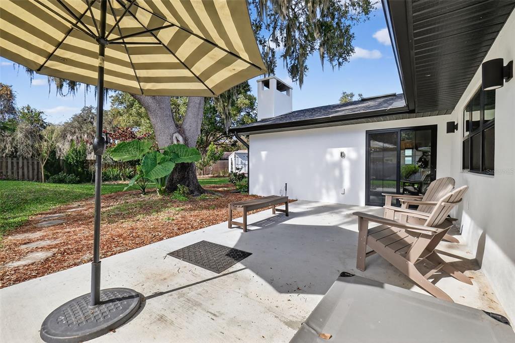 241 Bay Road Mount Dora, FL 32757 - Photo 38 of 57 a view of a patio with table and chairs under an umbrella