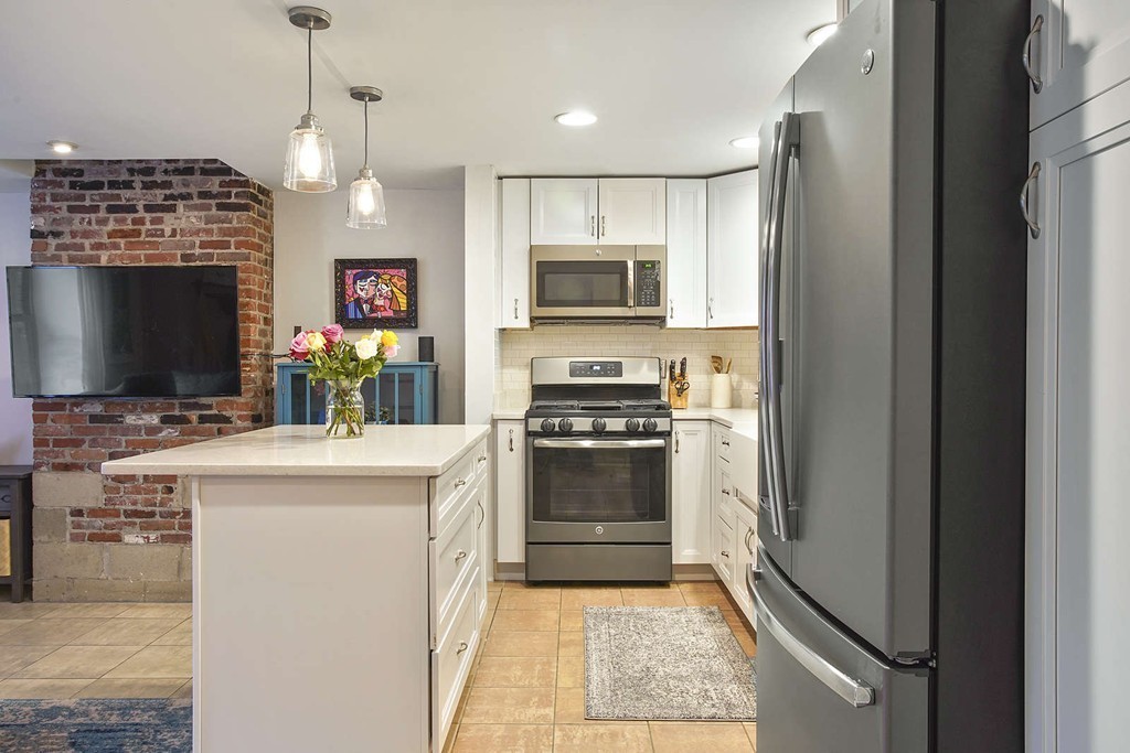 1670 Washington Street, Unit 6 Boston, MA 02118 - Photo 3 of 17 a kitchen with kitchen island a stove and a refrigerator