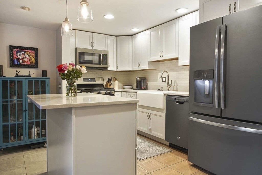 1670 Washington Street, Unit 6 Boston, MA 02118 - Photo 6 of 17 a kitchen with stainless steel appliances a sink stove refrigerator and cabinets
