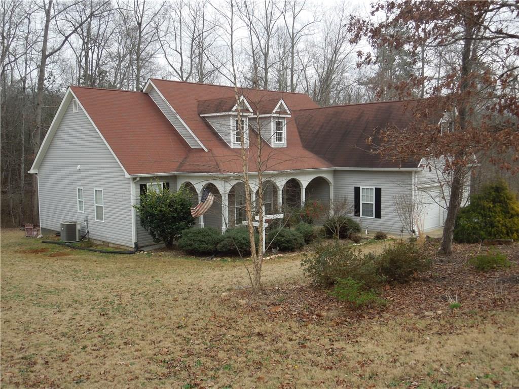 a view of a house with a yard and large tree
