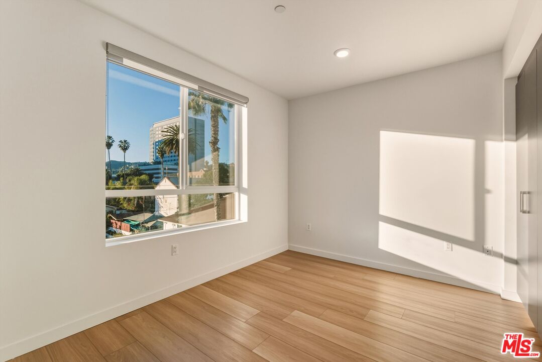 1759 North Gower Street, Unit 404 Los Angeles, CA 90028 - Photo 15 of 23 an empty room with wooden floor and windows