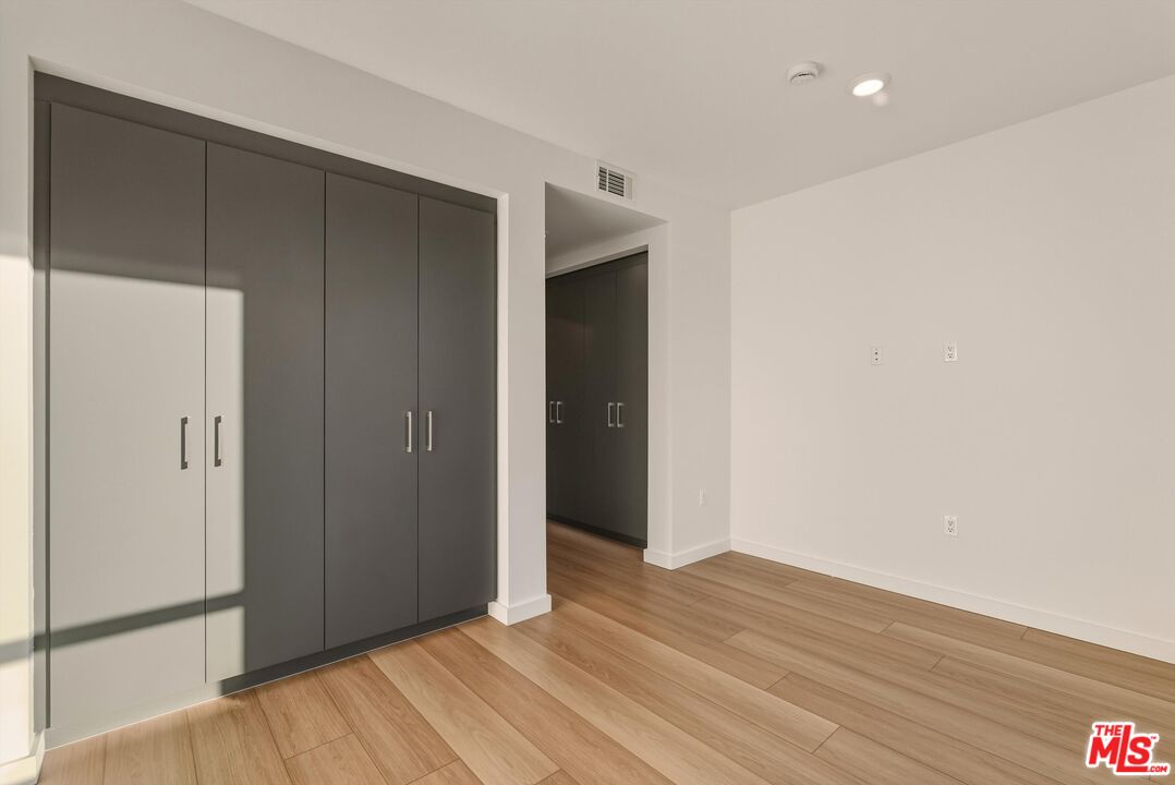 1759 North Gower Street, Unit 404 Los Angeles, CA 90028 - Photo 16 of 23 a view of an empty room with wooden floor and closet