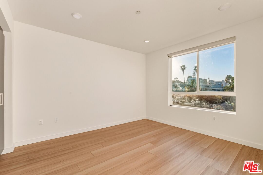1759 North Gower Street, Unit 404 Los Angeles, CA 90028 - Photo 19 of 23 an empty room with wooden floor and windows