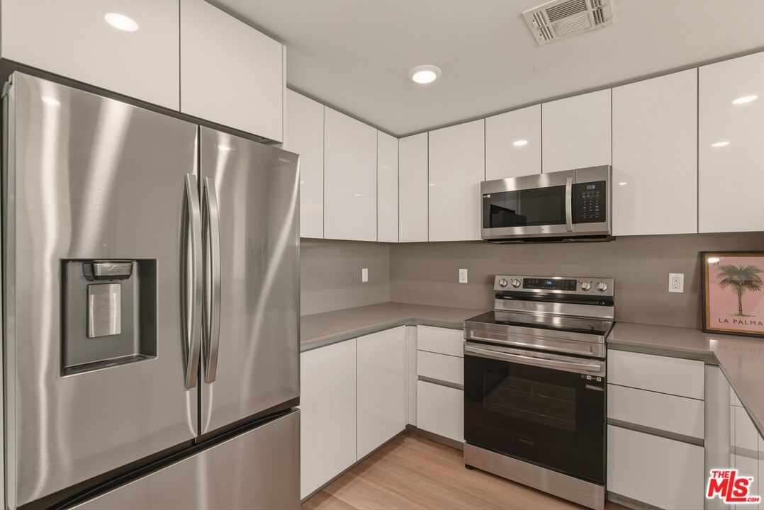 1759 North Gower Street, Unit 404 Los Angeles, CA 90028 - Photo 6 of 23 a kitchen with stainless steel appliances a refrigerator sink and microwave