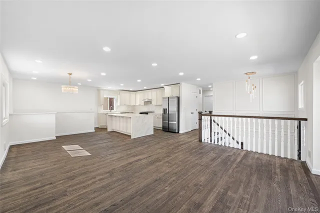 a view of kitchen with kitchen island wooden floor center island and stainless steel appliances