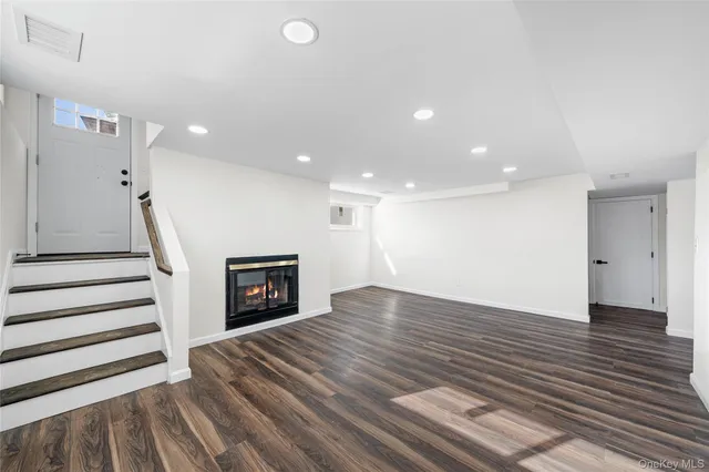 a view of a livingroom with wooden floor and a ceiling fan