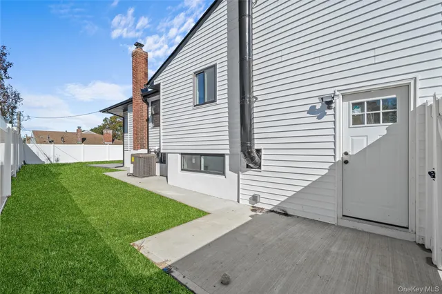 a view of a white house next to a yard
