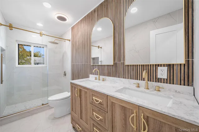 a bathroom with a sink a toilet and shower