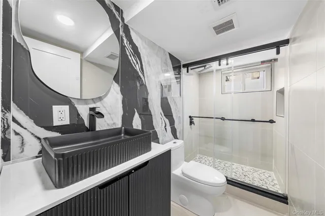 a bathroom with a toilet a sink and a mirror