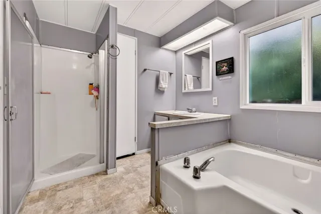 a bathroom with a tub a sink and a mirror