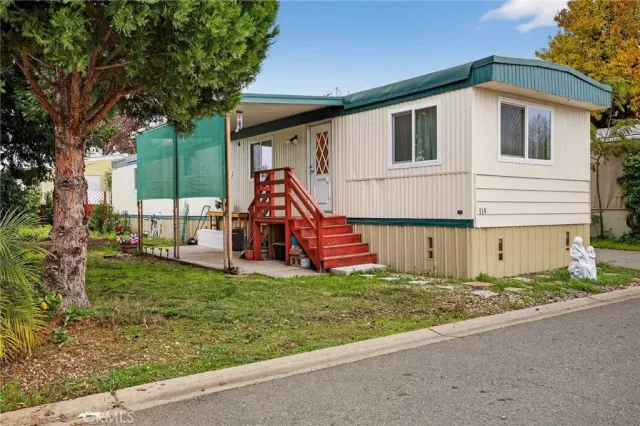 a view of a house with a yard and potted plants
