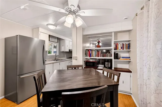 a kitchen with stainless steel appliances granite countertop a dining table chairs and refrigerator