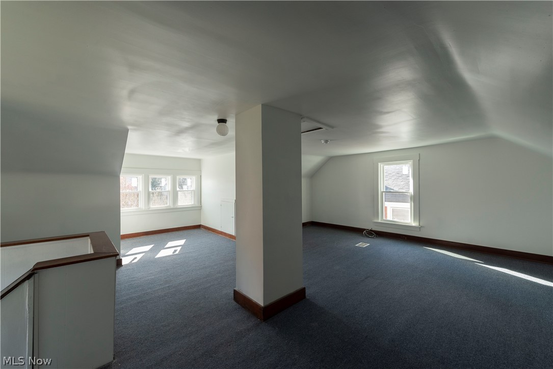 1022 North Howard Street Akron, OH 44310 - Photo 25 of 38 Bedroom 5 on the third floor featuring lofted ceiling, new windows and dark carpet