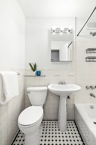 a bathroom with a sink a toilet and a mirror