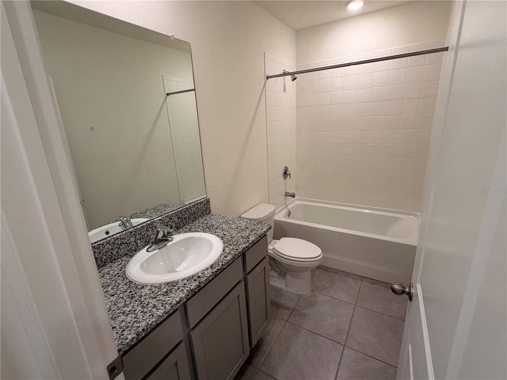 17534 Crescent Moon Loop Bradenton, FL 34211 - Photo 14 of 18 a bathroom with a granite countertop sink toilet and shower