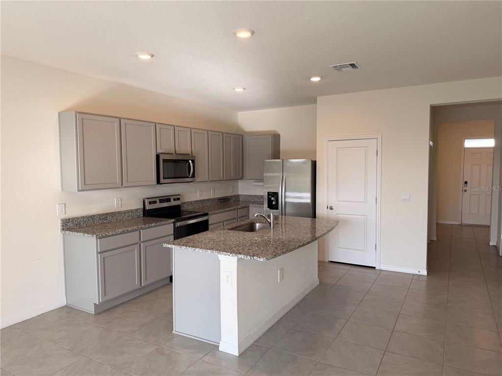 17534 Crescent Moon Loop Bradenton, FL 34211 - Photo 5 of 18 a kitchen with granite countertop a sink and white stainless steel appliances