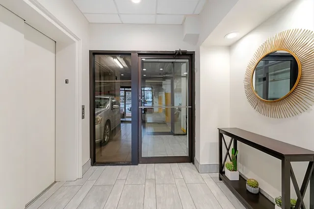 a view of a hallway with wooden floor and a living room