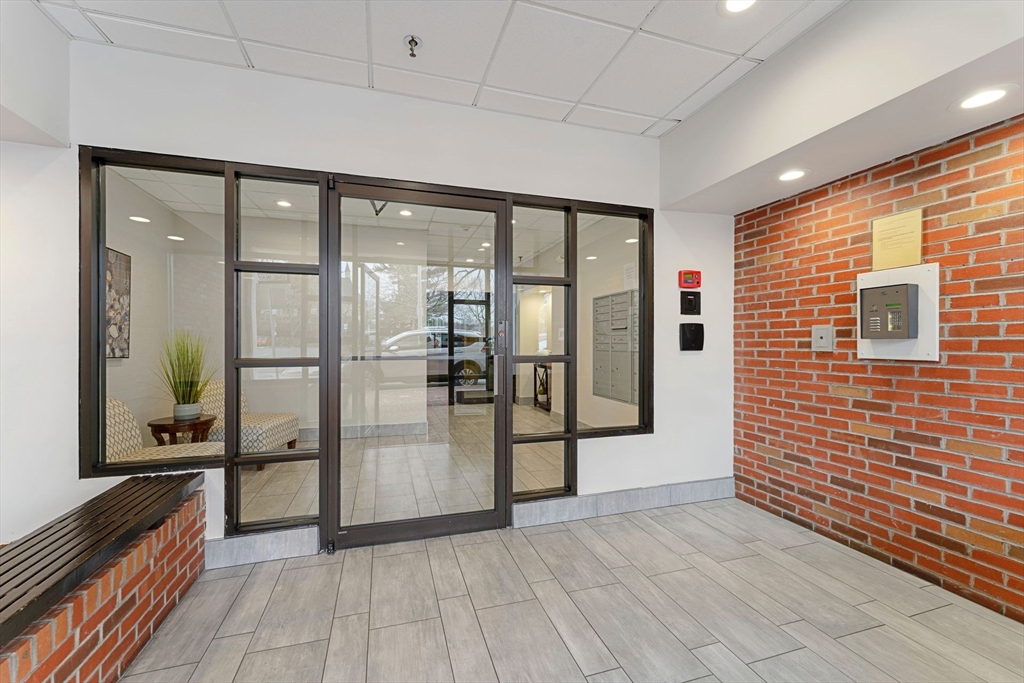 31 Spring Street, Unit 308 Watertown, MA 02472 - Photo 13 of 37 a view of a hallway with wooden floor and a living room