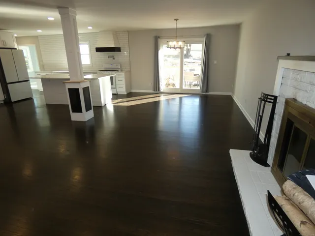 a view of a dining room with furniture a fireplace and wooden floor