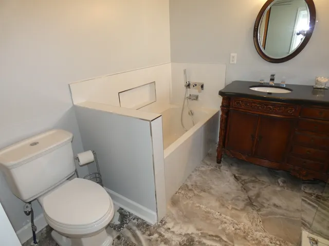 a bathroom with a toilet sink and mirror