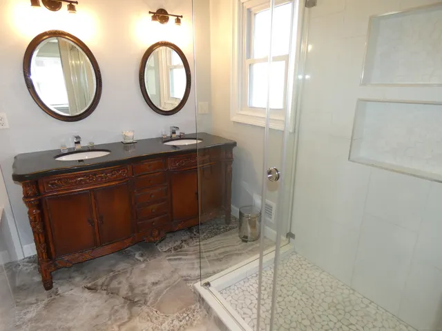 a bathroom with a toilet mirror vanity and a sink
